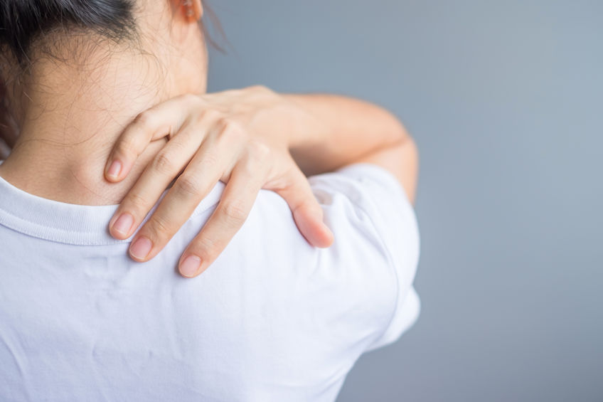woman holding shoulder that is in pain