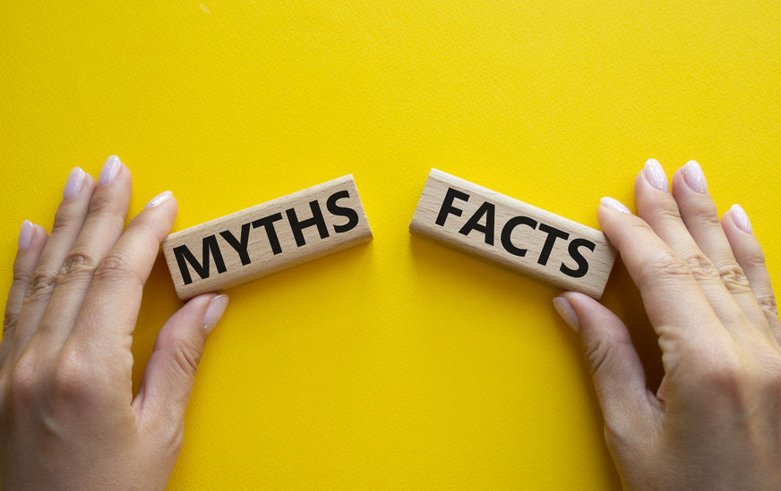 Little tile pieces reading "myths" and "facts" being held by two hands